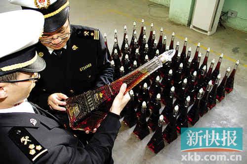海關關員清點查獲的涉嫌走私入境洋酒。